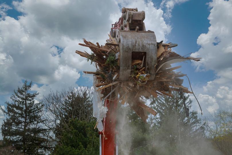 House being demolished by an excavator