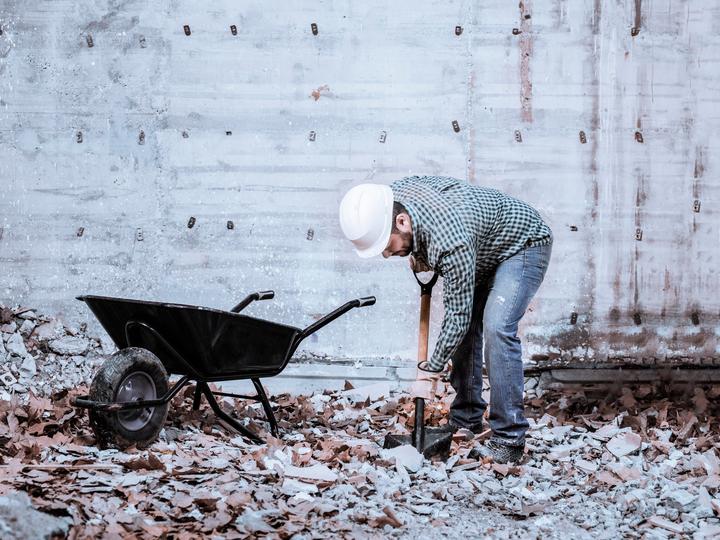 Worker operating a jackhammer for concrete demolition