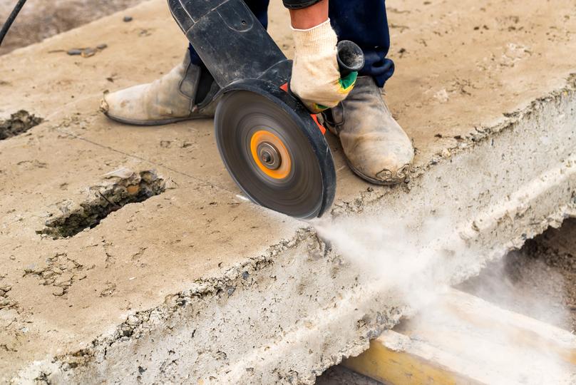 Worker operating a jackhammer for concrete demolition