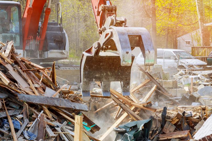 Commercial demolition contractor using specialized equipment to demolish a large building