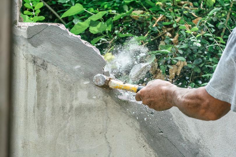 Worker operating a jackhammer for concrete demolition