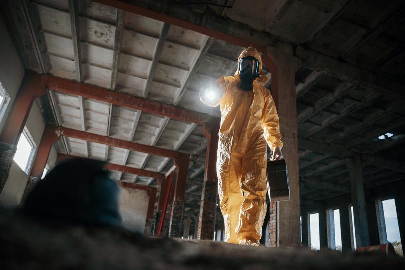 Workers in hazmat suits removing asbestos