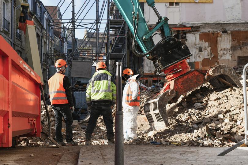 Worker operating a jackhammer for concrete demolition